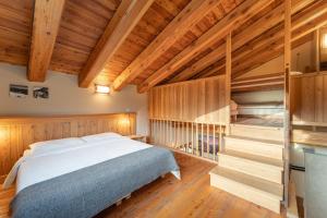 a bedroom with a bed and wooden walls and wooden floors at Civico 13 in Marmora