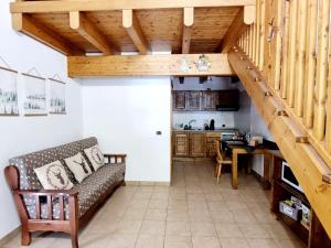 a living room with a couch and a staircase at Appartamento Adamello 9 in Pinzolo