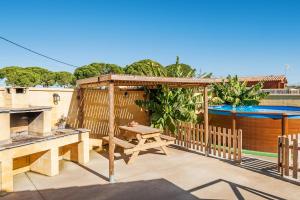 a patio with a picnic table and a swimming pool at Las tres hermanas in Conil de la Frontera