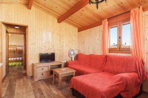 a living room with a red couch and a television at Las tres hermanas in Conil de la Frontera