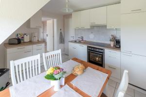 a kitchen with a wooden table with a vase of flowers at Haus Süderkamp in Langeneß