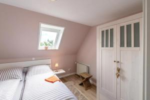 a small bedroom with a bed and a window at Haus Süderkamp in Langeneß