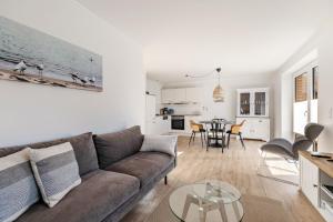a living room with a couch and a table at Ferienhaus Waterkant mit Hund in Klanxbüll