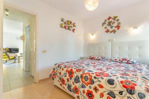 a bedroom with a bed with a colorful comforter at Casa Alvates in Corralejo +22 photos