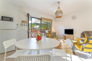 a dining room with a white table and chairs at Casa Alvates in Corralejo