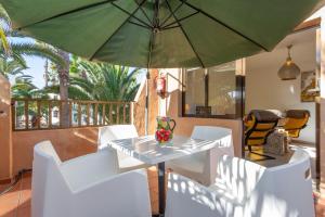 a table and chairs with an umbrella on a balcony at Casa Alvates in Corralejo