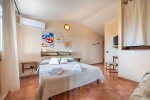 a bedroom with a bed with towels on it at Brezza di Mare in Calasetta
