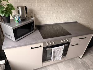 a kitchen with a microwave and a stove at Rosenhaus in Merchweiler