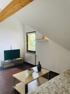 a living room with a table and a tv at Ferienwohnung Gaßmann in Wingerode