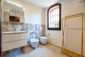 a bathroom with a toilet and a sink at Villa Grecale in Stintino +25 photos