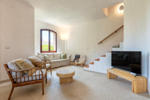 a living room with a couch and a tv at Villa Grecale in Stintino