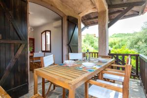 a wooden table and chairs on the balcony of a house at Villa Grecale in Stintino