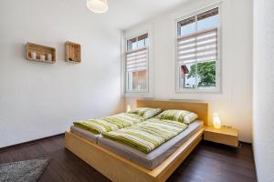 ein Schlafzimmer mit einem Bett und zwei Fenstern in der Unterkunft Quartier in Lauta