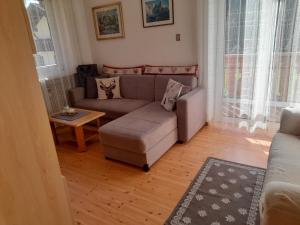 a living room with a couch and a table at Casa Defrancesco - with terrace in Moena