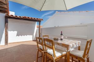 a dining room with a table and chairs and an umbrella at Casa vista golf in Caleta De Fuste +21 photos