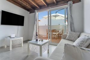 a living room with a couch and a tv and a table at Casa vista golf in Caleta De Fuste