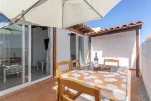 a dining room with a table and an umbrella at Casa vista golf in Caleta De Fuste