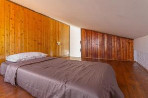 a bedroom with a bed with wooden walls and wooden floors at Casa vista golf in Caleta De Fuste