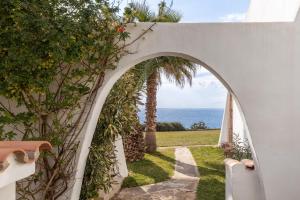 an archway leading to a garden with a view of the ocean at Cala Serena Beach 5 in Felanitx