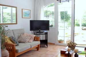 a living room with a couch and a flat screen tv at Las Tórtolas in Alaior