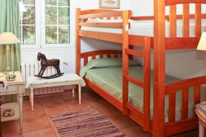 a bedroom with two bunk beds and a chair at Las Tórtolas in Alaior +17 photos