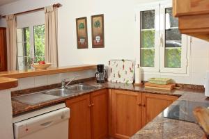 a kitchen with a sink and two windows at Las Tórtolas in Alaior