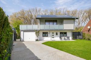 a white house with a garage and a lawn at Ferienhaus Schleibengel in Maasholm