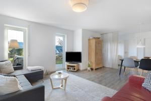 a living room with a couch and a tv and a table at Ferienwohnung Im Laubgarten in Öhningen