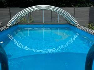 a large blue pool with a white arch over it at Ferienhaus Schleibengel in Maasholm