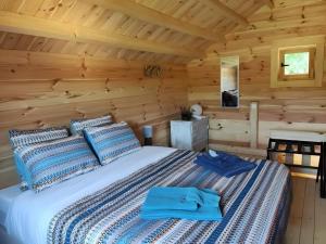 a bedroom with a bed in a log cabin at Au chant des oiseaux - rouge gorge in Varen +33 photos