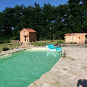 a swimming pool with a boat in the water at Au chant des oiseaux - rouge gorge in Varen