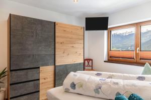a room with a couch and a wall with a television at Apart Elias in Gschnallenhof