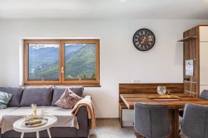 a living room with a couch and a table and a clock at Apart Elias in Gschnallenhof