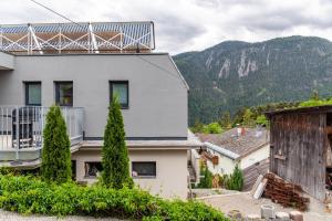 a house with a balcony and mountains in the background at Apart Elias in Gschnallenhof