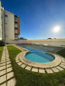 a swimming pool in the grass next to a building at Onda Beach House in Cortegaça
