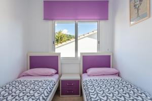two beds in a room with a window at Durero in Pineda de Mar +15 photos