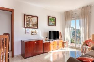 a living room with a flat screen tv on a cabinet at Durero in Pineda de Mar