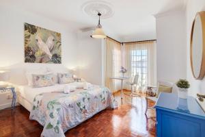 a white bedroom with a bed and a table at Sunshine House in Faro +26 photos