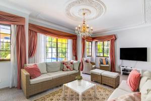 a living room with a couch and a chandelier at Sunshine House in Faro