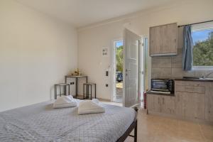 a white bedroom with a bed and a kitchen at Panagis Apartments in Argostoli +33 photos