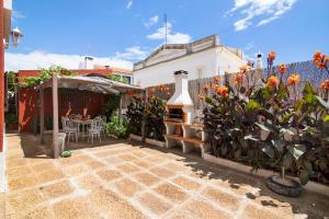 a patio with a fence and a table and some plants at Sunshine House in Faro