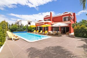a villa with a swimming pool in front of a house at Sunshine House in Faro