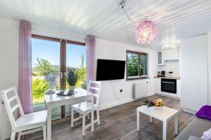a kitchen and living room with a table and chairs at db Staycation Ferienpark in Niedenstein