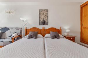 a bedroom with two twin beds and a couch at Apartamentos Martin - 22 in Puerto Naos