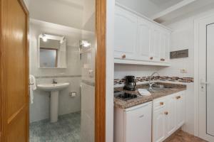 a white bathroom with a sink and a sink at Apartamentos Martin - 22 in Puerto Naos +18 photos