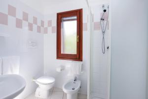 a bathroom with a toilet and a sink and a shower at mirtagru casa della Sughereta in Budoni