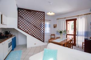 a kitchen and living room with a spiral staircase at mirtagru casa della Sughereta in Budoni +13 photos
