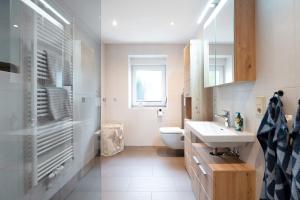 a bathroom with a sink and a toilet and a window at Fewo Traumschleife Nohen in Nohen +9 photos
