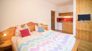 a bedroom with a bed with colorful pillows on it at Peter Paul Studio Penegal in Appiano sulla Strada del Vino