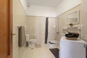 a white bathroom with a toilet and a sink at La Casa Bianco in El Cotillo +24 photos